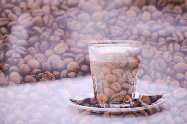 Multiple exposure of coffee beans and a glass of milk with coffee (caffelatte) on a table