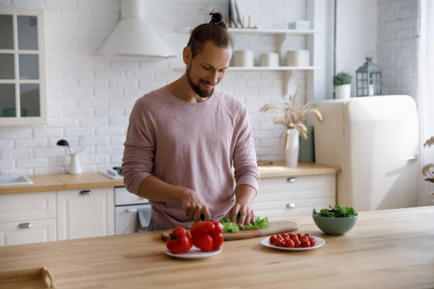 istock Happy young handsome man preparing healthy food in kitchen. 1410442280
