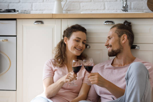 istock Happy affectionate young couple clinking glasses with wine. 1410442384