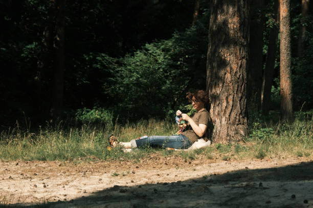 istock Woman is sitting under the tree and knitting 1410442533