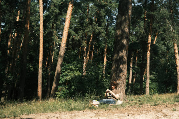 istock Woman is sitting under the tree and knitting 1410442787