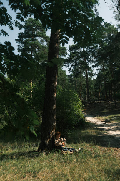 istock Woman is sitting under the tree and knitting 1410443010