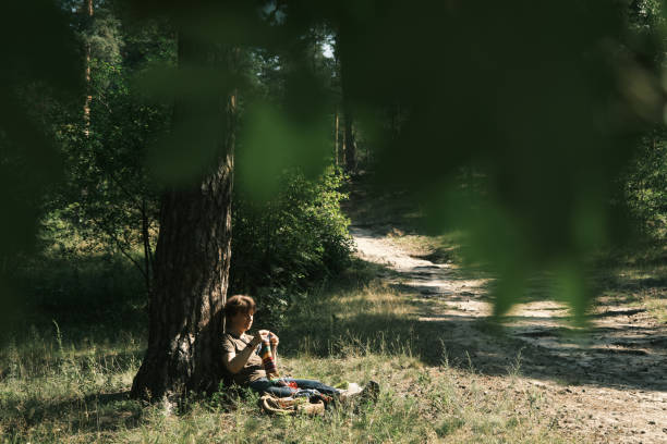 istock Woman is sitting under the tree and knitting 1410443067