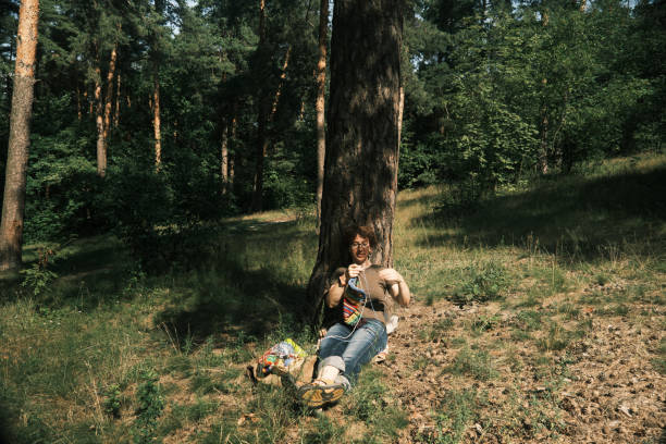 istock Woman is sitting under the tree and knitting 1410443087