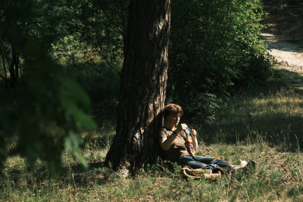 istock Woman is sitting under the tree and knitting 1410443145
