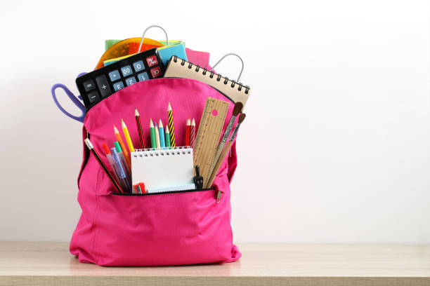 istock Pink backpack with school supplies on a white. 1410445435