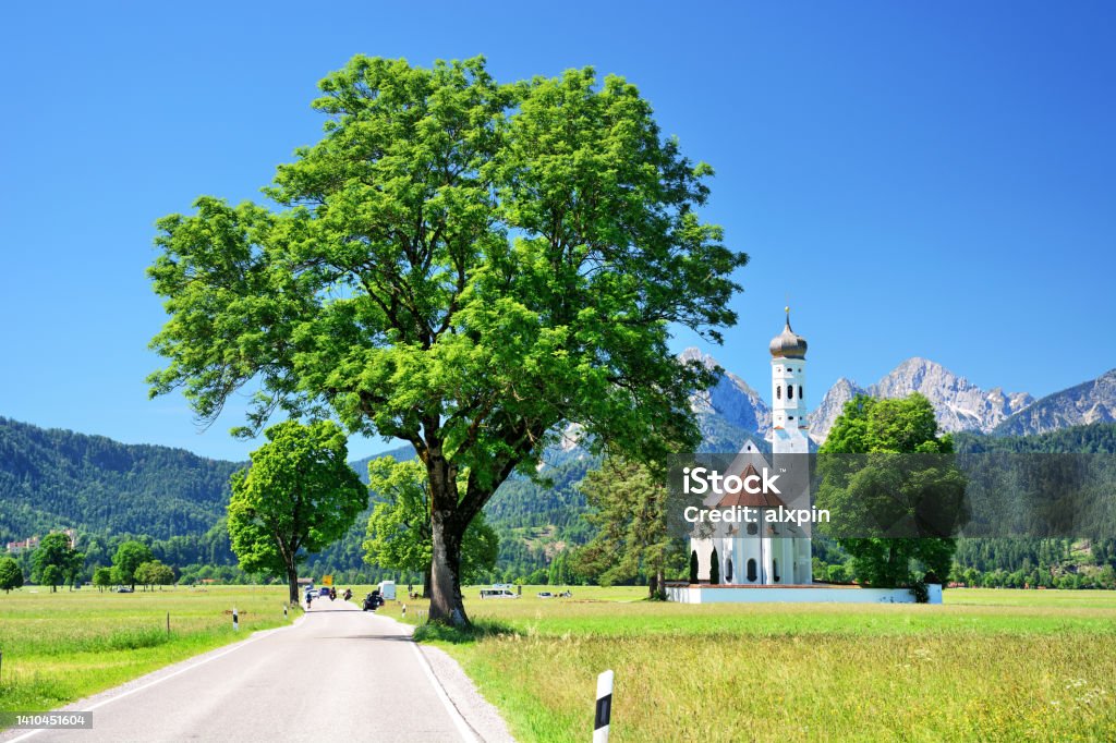 St. Coleman's Church, Bavaria St. Coleman's Church with mountains in background, Schwangau municipality, Bavaria, Germany Fussen Stock Photo