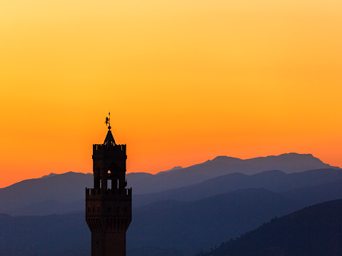 Sunset view at Palazzo vecchio tower in Florence with the mountains