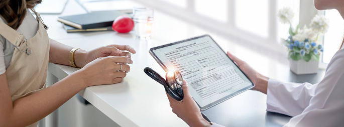 La doctora utiliza la tableta digital para explicar los resultados del diagnóstico a los pacientes en la sala de examen. Concepto médico sanitario. photo