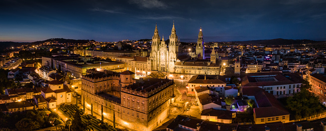 Illuminated City of Santiago de Compostela with famous Cathedral at Night. Aerial Drone Point of View Panorama overlooking the Cityscape. Santiago de Compostela, Galicia, Spain, Europe