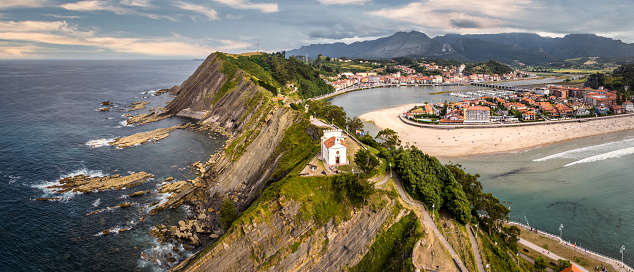 Ribadesella - Ribeseya Beach and Town Aerial Drone Point of View Panorama overlooking the coastal cliffs towards the beach and town.\nRibadesella, Asturias, Spain, Europe.