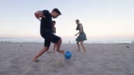 istock Teenage kids playing soccer on on beach 1410455273
