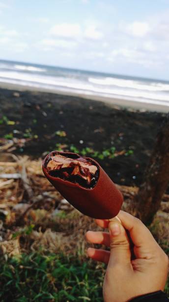 Woman Holding Chocolate Ice Cream at Beach