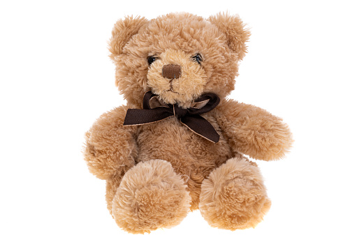 brown teddy bear lies wrapped in a white soft blanket, space for text