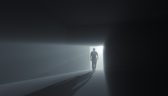 Go into the light concept. A man goes into the light from the heaven doors in a minimalist room - the concept of leaving the world