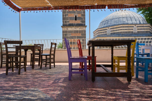 empty wooden chairs and tables at the roof Sheikh Matar Mosque empty wooden chairs and tables at the roof Sheikh Matar Mosque and dubbed the Four-legged Minaret in Diyarbakir, Turkiye. Local name is seyh matar cami ve dort ayakli minare. escort bayan diyarbakır stock pictures, royalty-free photos & images