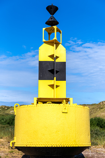 Yellow buoy in the at land on a blue background