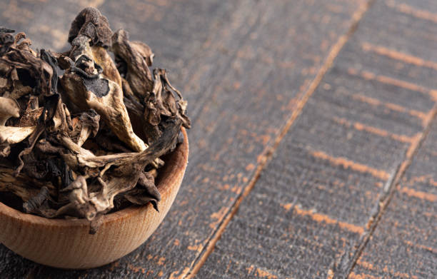 istock Wild Black Trumpet Mushrooms on a Rustic Wooden Table 1410470669