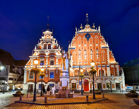 Riga, Latvia - August 6, 2019: front view City Hall Square with House of the Blackheads and Saint Peter church in Old Town of Riga at dusk, Latvia