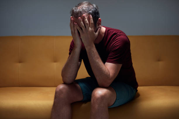 istock Man with headache pain, anxiety, depression, sadness at home. 1410471700