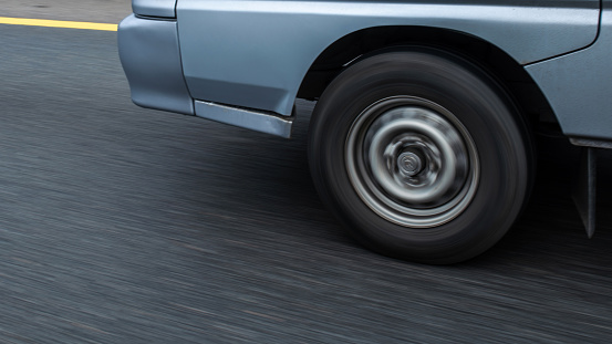 Close-up shot of the car wheel in motion at highway