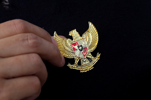 Yogyakarta, Indonesia - May 23, 2021 : Hand with Garuda Pancasila on clothes, Indonesia's Nastional Symbol. Indonesia independence day 17th August.