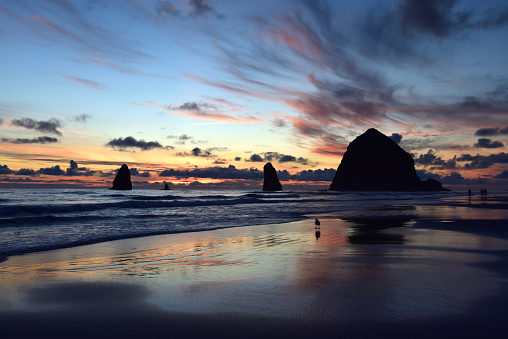 A colorful sunset at Cannon Beach, Oregon, with Haystack Rock in Silhouette.