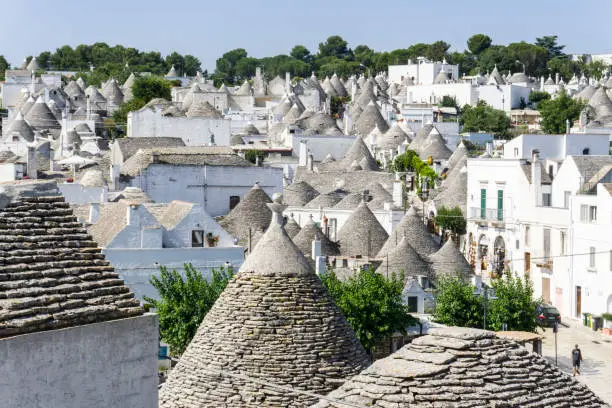 Trulli houses with painted symbols on the conical roofs in Alberobello, Italy, Puglia UNESCO world heritage site.