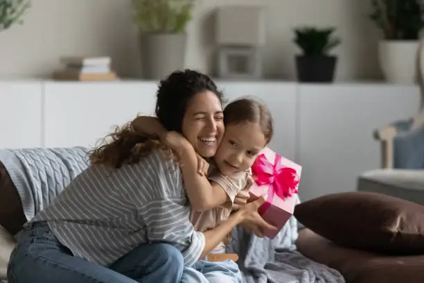Loving mother congratulates little 6s daughter on her birthday, mom receive congrats and gift box from her kid on eight march International Woman or Happy Mother Day, life events celebrations concept
