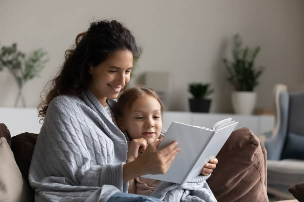 istock Loving mom reads a book to her daughter 1410485234