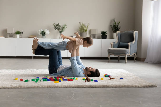 istock Dad lying on floor play with little cute daughter 1410485246