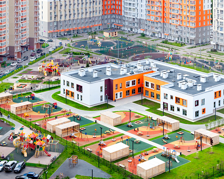 Public school building. Exterior view of school building with playground mixed-use urban multi-family residential district area development. Urban development concept image. Back to school concept.