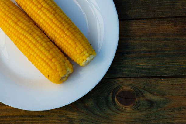 istock boiled corn on cobs white plate Fresh sweet on rustic wooden table, closeup, Cooked corn, Homemade golden salt, healthy vegan snack Delicious 1410486226