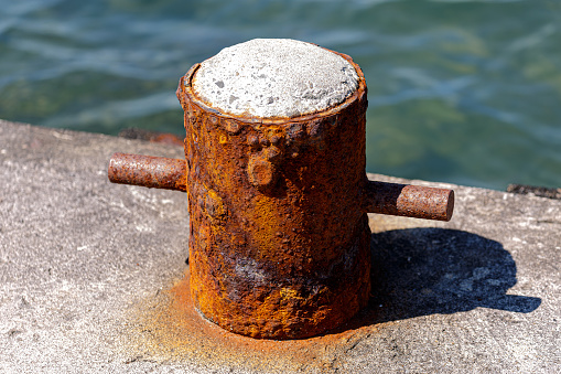 Old rusty mooring equpment on concrete pier