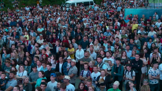 a crowd of spectators at an outdoor rock concert in a park in Ufa on a summer evening