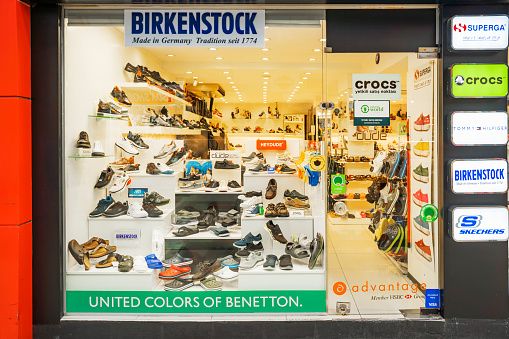 Retail display of fashion shoes displayed in a shoe store shop in Turkey. The boots are neatly  displayed lined up and include brands like Birkenstockand Crocs. June 26, 2022 Turkey, Marmaris