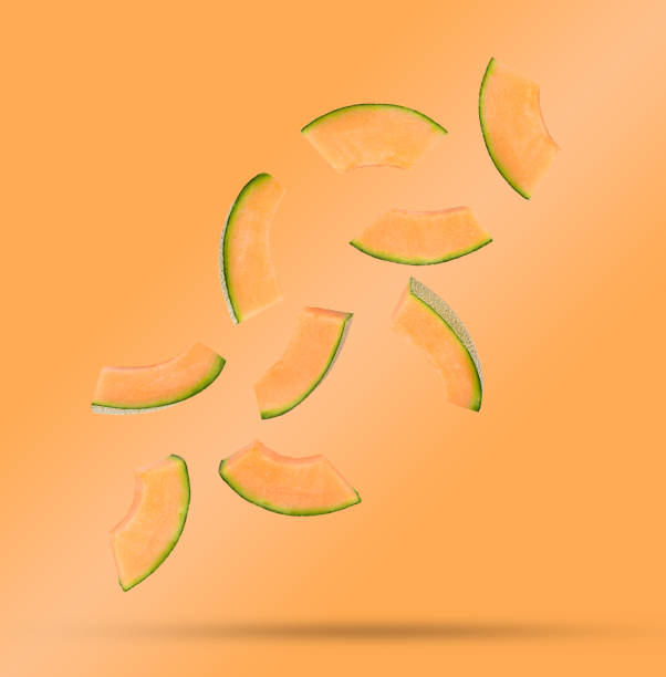 istock Flying fresh cantaloupe melon slices isolated on orange 1410501274