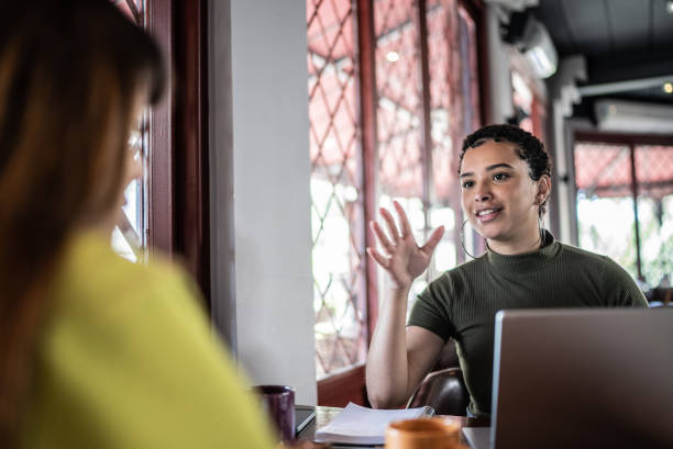 mujeres jóvenes en una reunión en un restaurante - chat dar fotografías e imágenes de stock