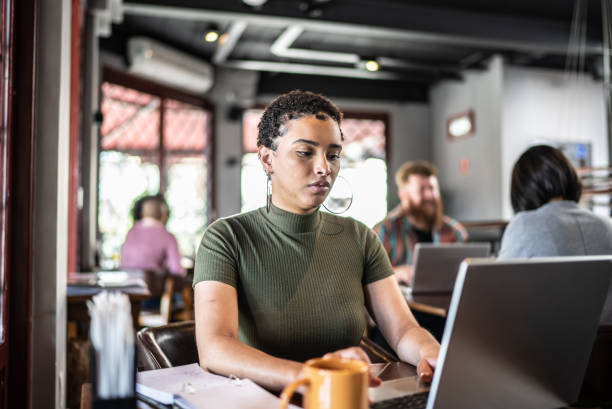 istock Young woman using the laptop in a restaurant 1410506355
