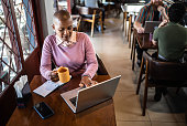 istock Mature woman using the laptop in a restaurant 1410506385