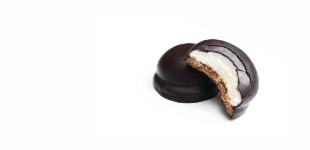 istock Two chocolate covered marshmallows isolated on white background. One with bite on it 1410509077