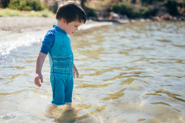 istock Cute little boy playing with sand at the beach 1410510419