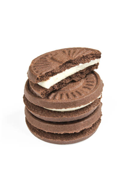 istock Filled tea biscuits isolated on white background. Chocolate sandwich cookie with milk filling cracked 1410510902