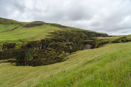 Incidental people at the Fjaðrárgljúfur Canyon with Fjadra river, 2 km long and 100m deep canyon in South East of Iceland.