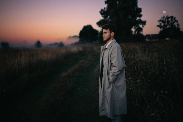 istock man thinker, philosopher poet walks in a raincoat across the field at dawn. 1410517316