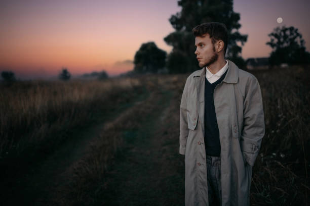 istock man thinker, philosopher poet walks in a raincoat across the field at dawn. 1410517323