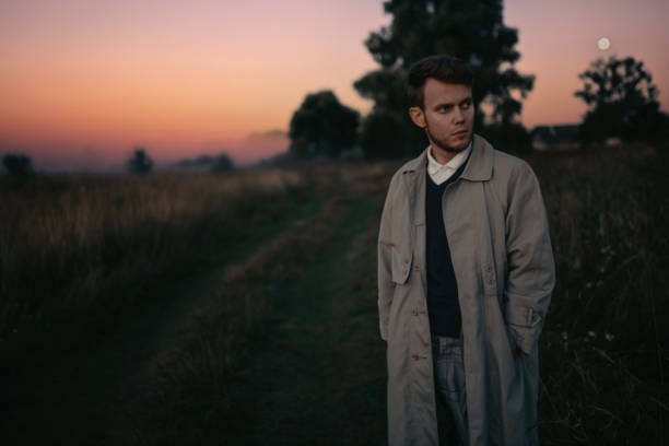 istock man thinker, philosopher poet walks in a raincoat across the field at dawn. 1410517328
