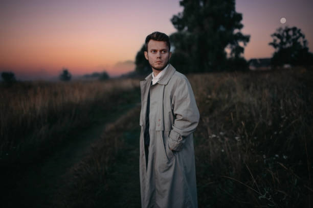 istock man thinker, philosopher poet walks in a raincoat across the field at dawn. 1410517331