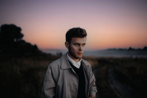 istock man thinker, philosopher poet walks in a raincoat across the field at dawn. 1410517334