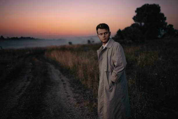 istock man thinker, philosopher poet walks in a raincoat across the field at dawn. 1410517339